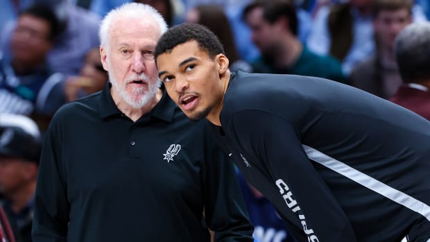 San Antonio Spurs coach Gregg Popovich speaks with San Antonio Spurs center Victor Wembanyama (1) before the game against the Dallas Mavericks at American Airlines Center.